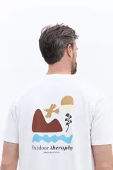 Remera de manga corta color blanco con cuello redondo y calce regular. Presenta un diseño estampado en la espalda con motivos naturales abstractos y la inscripción Outdoor theraphy.
