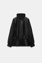Chaqueta de piel con cuello alto y manga larga con puños. Presenta un diseño con cintura ajustable mediante cordón elástico, bolsillos frontales y cierre de cremallera metálica con solapa de botones a presión.