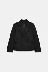 Blazer corto de corte oversize con estampado de cuadros, cuello con solapas de muesca y manga larga. Presenta cierre frontal cruzado con un botón y falsos bolsillos de vivo en el delantero. Incluye forro interior.
