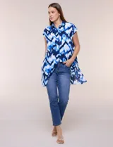 Túnica de gasa negra con estampado floral en tonos azules y blancos, cuello camisero, manga corta y cierre frontal de botones.