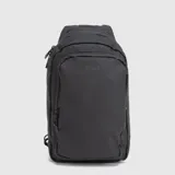 Riñonera bandolera de diseño ergonómico, color negro, con cierre principal y compartimento frontal. Cuenta con correa ajustable y cierres waterproof, permitiendo su uso cruzado al frente o en la espalda.