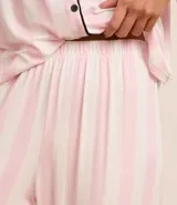 Conjunto de pijama largo de viscosa estampada a rayas verticales, compuesto por una camisa de manga larga con cuello solapa y abotonado delantero, y un pantalón con cintura elástica.