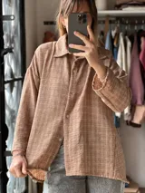 Camisa de manga larga color tostado con diseño de cuadrillé fino, cuello camisero y cierre frontal con botones.