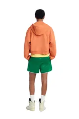 Sudadera cropped fit con capucha y cierre frontal de cremallera, confeccionada en tejido de algodón en color naranja. Cuenta con bolsillos frontales tipo canguro y efecto lavado.