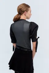 Top negro con escote en V, mangas abullonadas con lazos y cuerpo con lurex plateado.