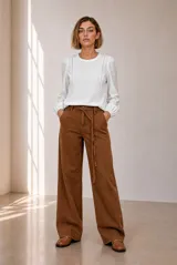 Remera blanca de manga larga con detalles de encaje en el frente y puños elásticos.
