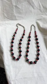 Collar compuesto por piedras ágata DZI, cuentas de vidrio y cristal checo en color negro y rojo, con cadena metálica en los extremos.