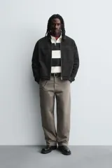 Sobrecamisa de denim de algodón negro con efecto lavado, corte relajado (relaxed fit). Presenta cuello solapa, cierre frontal con cremallera, manga larga con puño abotonado y bolsillo plastrón en el pecho.