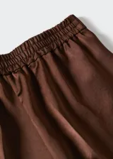 Pantalón de vestir de corte recto y tejido satinado fluido. Presenta una cintura elástica sin cierre y un diseño elegante de estilo traje.