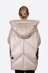 Campera tipo capa acolchada, con capucha y cierre frontal de botones a presión. El exterior es de nylon color beige claro metalizado y el forro de la capucha es verde militar.