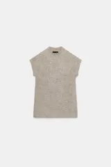 Top de punto color beige, con cuello subido, manga corta y detalle de tejido efecto cepillado.