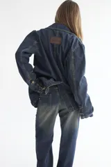 Blazer de denim azul oscuro con forro interior color verde oliva. Presenta un corte estructurado y solapas clásicas.