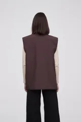 Chaleco marrón con cierre frontal y bolsillos con cierre.