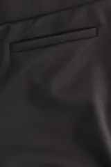 Pantalón de tiro alto confeccionado en punto roma, con diseño ajustado en la parte superior y piernas acampanadas. Presenta bolsillos insertados decorativos en la parte frontal.