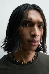 Camiseta relaxed fit color gris oscuro, confeccionada en tejido ligero de algodón con elasticidad. Presenta cuello redondo y manga ranglán corta.