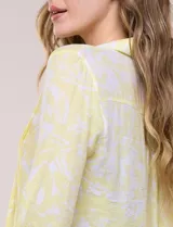 Blusa celeste con estampado efecto pincelada blanca, de corte semi holgado, escote en V con cuello solapa y media abotonadura frontal con botones nacarados. Presenta finas alforzas verticales en la pechera y mangas 3/4 con puños elastizados.