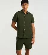 Bermuda masculina de corte recto, confeccionada en algodón con textura de cuadros verticales. Presenta cintura elástica con cordón ajustable y bolsillos laterales.