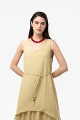Vestido largo color tostado con silueta relajada, escote en V, sin mangas y diseño de falda en capas. Cuenta con un lazo fino regulable en la cintura.