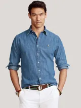 Camisa de denim celeste, corte regular, con cuello button-down, mangas largas con puños abotonados y logo bordado en el pecho.