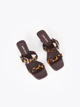 Sandalia de taco bajo con estampa animal print de leopardo, tiras finas de cuero, hebilla metálica y dijes colgantes.