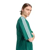 Remera de algodón color verde con diseño oversize, cuello redondo y mangas cortas. Presenta el logo Trefoil bordado en blanco en el pecho y las icónicas tres tiras de la marca en color blanco a lo largo de los hombros y mangas.