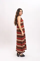 Vestido largo de tejido de punto con patrón en zigzag de rayas en tonos marrón, rojo, negro y beige, sin mangas y con escote redondo.
