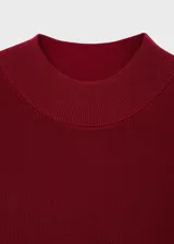 Vestido corto de tejido de punto fino en color bordó, con cuello perkins y mangas cortas. Presenta un diseño evasé que se ajusta suavemente al cuerpo.