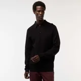 Remera de manga larga negra con cuello polo y tapeta de dos botones. Presenta un tejido de punto de fantasía con textura de pequeños puntos.