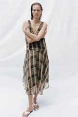 Vestido midi de escote en V y tirantes anchos, con bajo asimétrico y estampado de cuadros en tonos marrones, negros y beige.