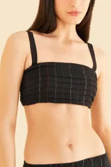 Top negro con volantes y pespuntes brillantes, escote cuadrado delante y detrás, tirantes con ajustadores y detalle de solapa en capas en el busto.