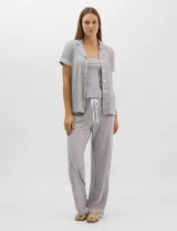 Set de pijama de tres piezas gris melange compuesto por camisa de manga corta con botones, musculosa básica de tirantes y pantalón largo con cordón ajustable en la cintura.