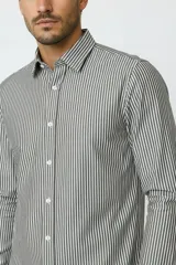 Camisa de algodón de manga larga con diseño de rayas verticales en tonos gris y blanco, cuello camisero clásico y cierre frontal con botones.