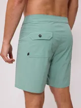 Short de baño color verde menta con cordón de ajuste en la cintura y una franja lateral con diseño de rayas en negro y blanco.
