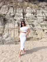 Conjunto de dos piezas compuesto por un top de escote bote y una falda midi, ambos confeccionados en tela bambula elastizada de textura arrugada.