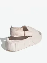 Sandalias Adidas Adifom Adilette XLG color beige, con diseño futurista y proporciones actualizadas. Cuenta con banda ajustable y estructura de una sola pieza de EVA biológico.