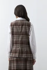 Chaleco de sastrería con estampado de cuadros en tonos tierra, diseño estructurado con escote en V y cierre frontal con botones.