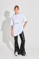 Remerón de corte oversized confeccionado en algodón, con cuello redondo y mangas cortas. Presenta estampados gráficos en color negro en la parte frontal.