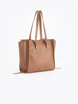 Bolso tipo tote de cuero color tostado con doble asa de hombro, detalles de hebillas metálicas en el frente y cierres laterales decorativos.