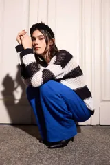 Sweater ligero de punto bicolor a rayas horizontales blancas y negras, con diseño holgado, mangas largas y detalles de costuras en zigzag a contratono.