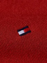 Sweater de punto rojo con cuello en V y logo de Tommy Hilfiger bordado en el pecho.