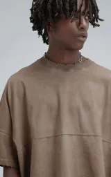 Remera de manga corta con calce extra oversize, color marrón chocolate con efecto gastado/deslavado. Presenta un corte con recortes horizontales en el frente y la espalda, y cuello redondo con terminación deshilachada.
