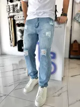 Pantalón mom jean de corte oversize, color celeste claro, con roturas y efecto desgastado en las piernas.