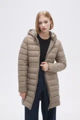 Campera acolchada color beige, de corte largo, con capucha y cierre frontal con cremallera.