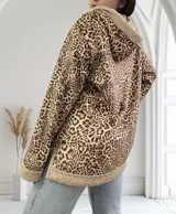 Campera con capucha de pana con estampado animal print y forro de piel sintética color crema. Tiene bolsillos delanteros y cierre con botones a presión plateados.