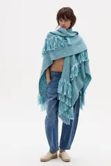 Ruana tejida en lana merino color celeste con flecos.