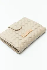 Billetera de mujer Daniel Cassin con diseño trenzado, cierre con broche a presión y placa metálica dorada con el logo de la marca en el frente.