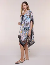 Kimono de gasa ligera con estampado floral en tonos marrones, amarillos y turquesas sobre base blanca, de corte amplio y abierto al frente, con mangas cortas tipo kimono y detalles de borlas en el ruedo asimétrico.