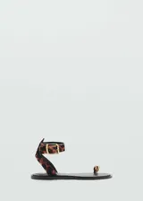 Sandalias planas de cuero con pelo de potro y estampado de leopardo. Poseen tira al tobillo con hebilla metálica y detalle de anillo metálico en la presilla para el dedo.