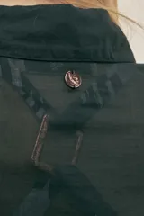 Vestido camisero largo negro de algodón con lazo en la cintura, botones nacarados y detalle de Polonio en cobre. Hecho en Italia.