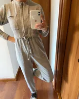 Mono largo negro de corte holgado, con cuello redondo, mangas largas, cierre frontal con botones a presión, bolsillos en el pecho y laterales, y cintura ajustable con cordón.